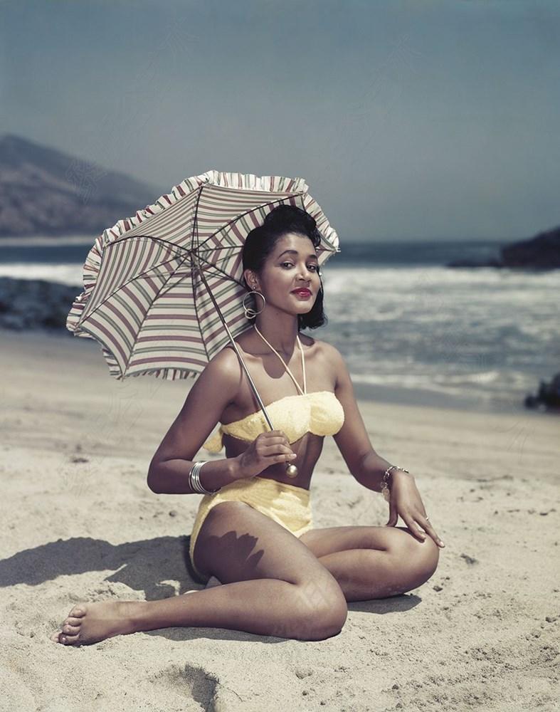 Woman on Beach Holding Umbrella